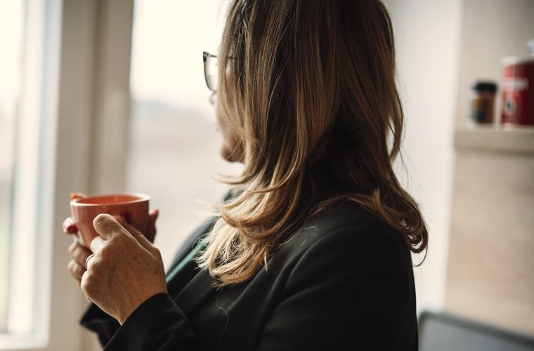 A woman at home by the window, at ease &mdash; her plan is done